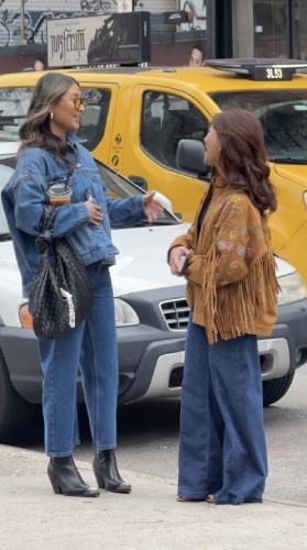 black and yellow sunglasses, a black leather woven bag, and block-heeled ankle boots