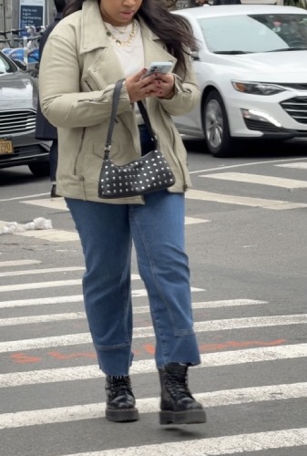 taupe leather jacket and a studded shoulder bag