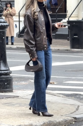 blue bootcut jeans, a black turtleneck, and brown boots