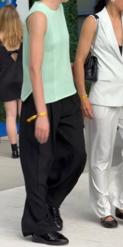 green crochet mock neck top paired with sleek black trousers