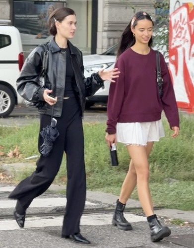 black leather coat layered over a black tee and tailored trousers