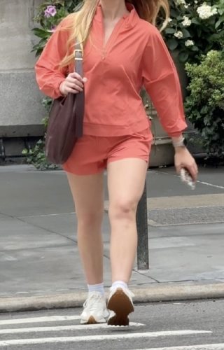 vibrant orange quarter-zip and shorts set with a brown suede buckle bag