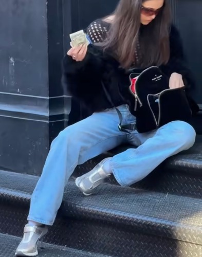 black shawl with open holes beneath a fur coat